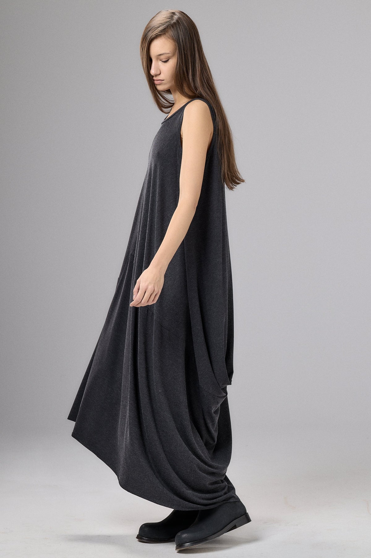 Woman wearing a black sleeveless dress on a gray background